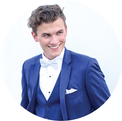 Man wear a white bow, tie, pocket square, and medium blue tux, vest for prom